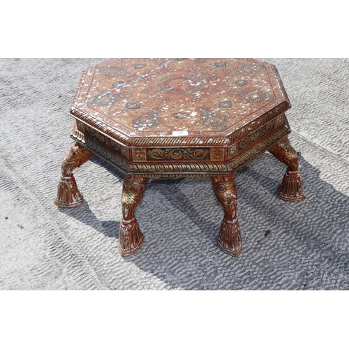 774 - A Kashmiri low prayer table, the octagonal top on eight hoof support legs, 67cms wide.