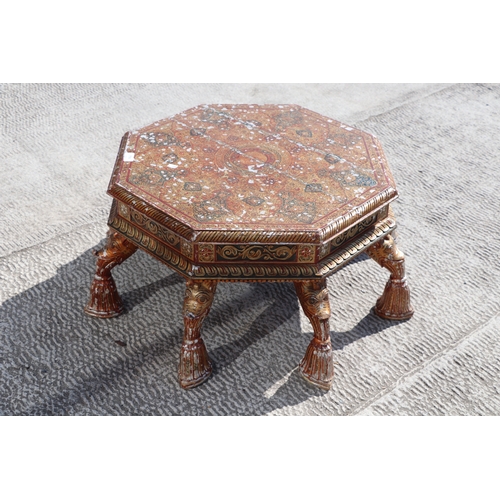 774 - A Kashmiri low prayer table, the octagonal top on eight hoof support legs, 67cms wide.