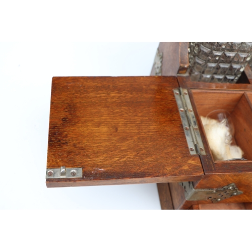 342 - A late 19th century oak three bottle Tantalus, the front section opening to reveal compartments cont... 