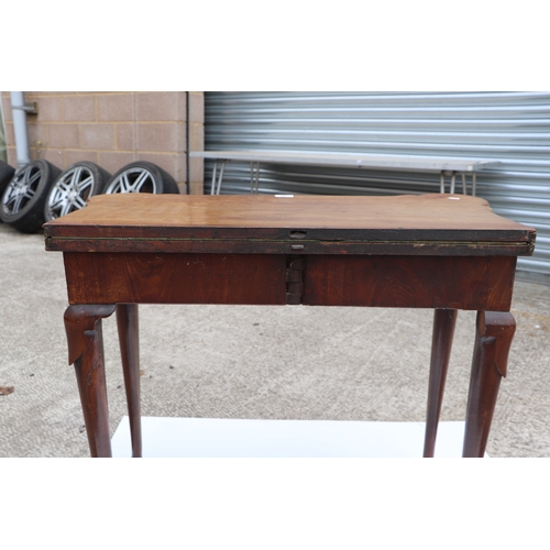 749 - A George III mahogany card table on turned legs terminating in pad feet, 84cms wide.