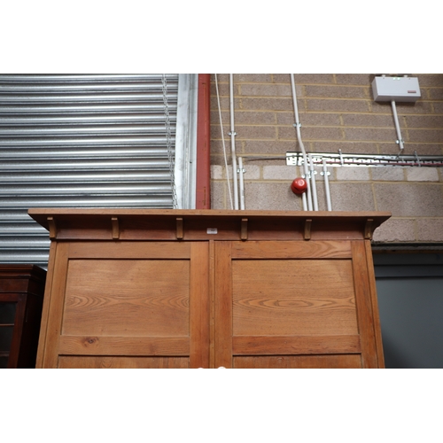 757 - A pine linen press, the upper section with a moulded cornice above two panelled doors enclosing a sh... 