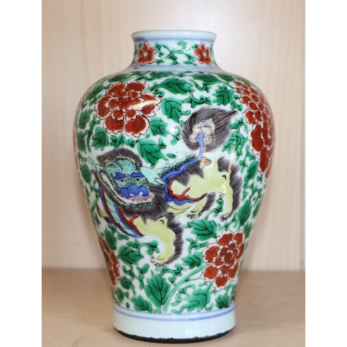 579 - A Chinese famille verte baluster vase decorated with shishi and prunus, 19cms high