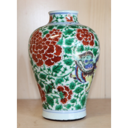 579 - A Chinese famille verte baluster vase decorated with shishi and prunus, 19cms high