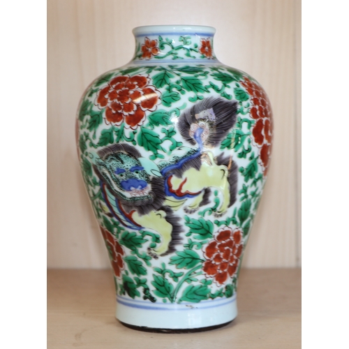 579 - A Chinese famille verte baluster vase decorated with shishi and prunus, 19cms high