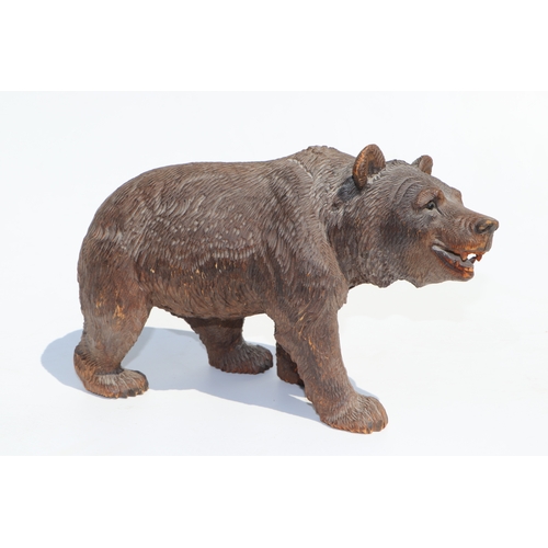 398 - A large Black Forest type carved figure of a walking bear, 28cms long; together with another similar... 