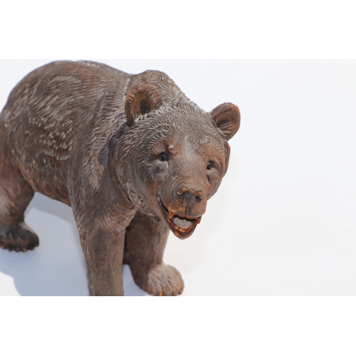 398 - A large Black Forest type carved figure of a walking bear, 28cms long; together with another similar... 