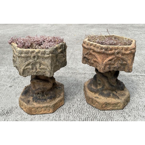 12 - A pair of well weathered terracotta planters on stands of hexagonal form, on intertwined snake colum... 