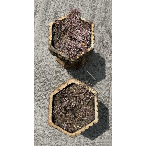 12 - A pair of well weathered terracotta planters on stands of hexagonal form, on intertwined snake colum... 