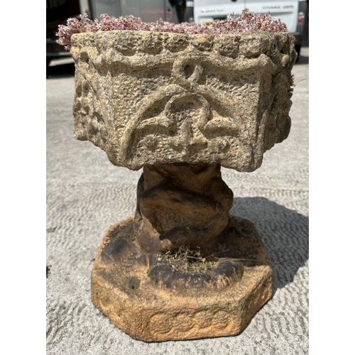 12 - A pair of well weathered terracotta planters on stands of hexagonal form, on intertwined snake colum... 