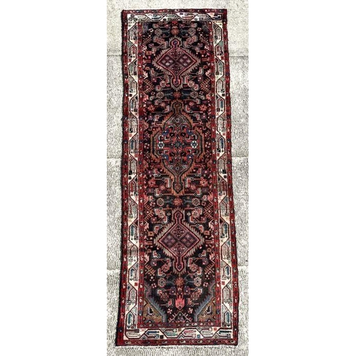 128 - A Persian Hamadan runner on a red ground, 280 by 80cms (333).