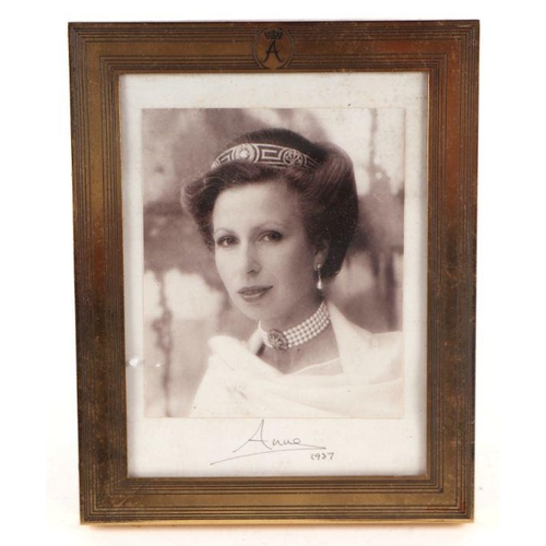 28 - A photograph of Princess Anne with facsimile signature and dated 1987, in a gilt metal strut frame o... 