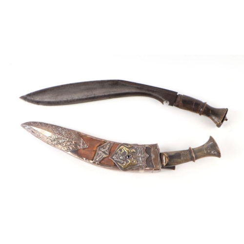 40 - A horn handled kukri in a wooden scabbard with white metal overlay decoration depicting an armorial ... 