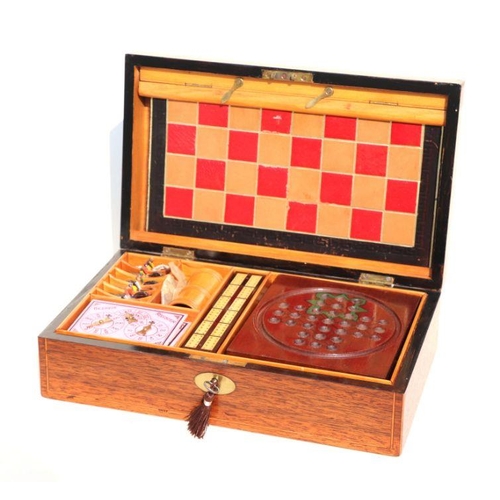 607 - An early 20th century mahogany games compendium fully fitted with dominoes, chess, draughts, cribbag... 