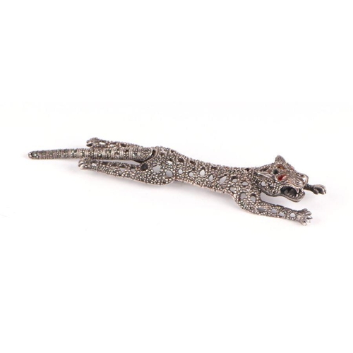 737 - A Cartier style silver panther brooch with red glass eyes and articulated tail, stamped 925, 29g