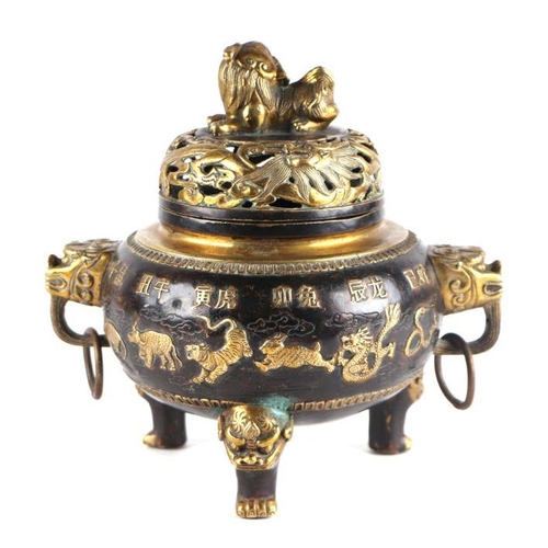 755 - A Chinese bronze censer and cover, the cover having a Fo dog finial, the body having ring handles an... 