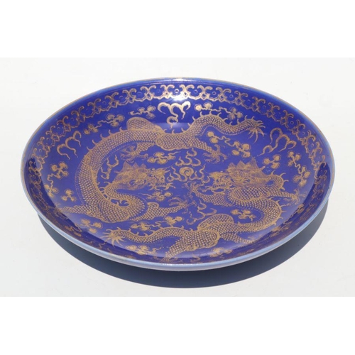 786 - A Chinese gilt decorated blue ground bowl depicting dragons amongst clouds chasing a flaming pearl, ... 