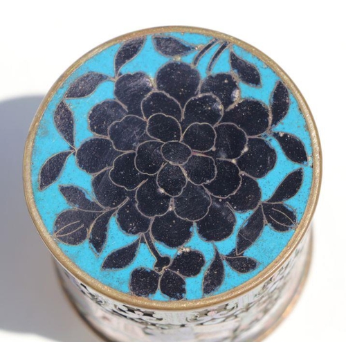 787 - A Chinese cloisonne box and cover of cylindrical form decorated with precious objects, 9.5cms high.