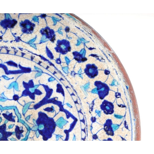 804 - An Iznik pottery charger with traditional blue and turquoise decoration, 36cm diameter.