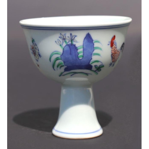 811 - A Chinese porcelain stem cup decorated with cockerels, chicks and flowers, 8.5cm diameter.