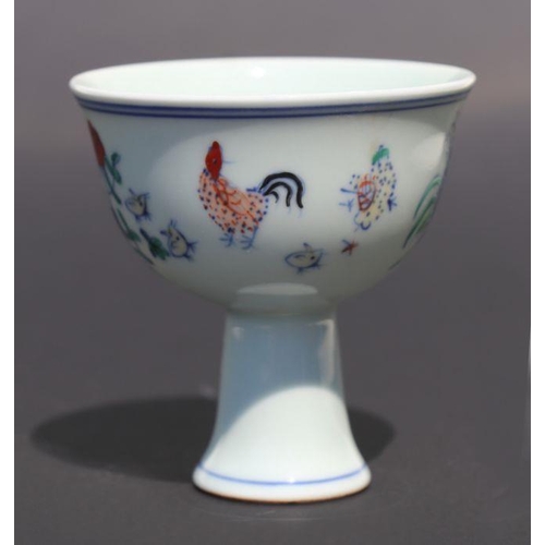 811 - A Chinese porcelain stem cup decorated with cockerels, chicks and flowers, 8.5cm diameter.