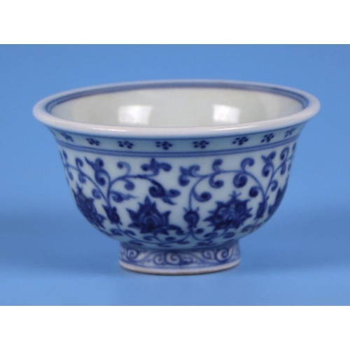 819 - A Chinese blue & white footed bowl decorated with scrolling flowering foliage, 9.5cms diameter.