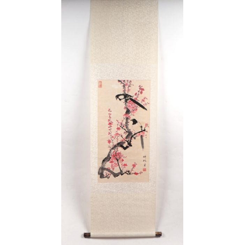 859 - A Chinese scroll painting depicting magpies within prunus, 152cm long.