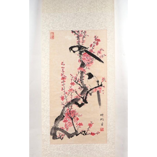 859 - A Chinese scroll painting depicting magpies within prunus, 152cm long.