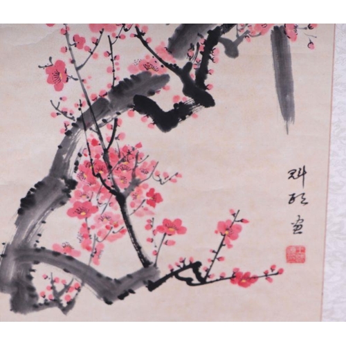 859 - A Chinese scroll painting depicting magpies within prunus, 152cm long.