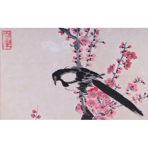 859 - A Chinese scroll painting depicting magpies within prunus, 152cm long.