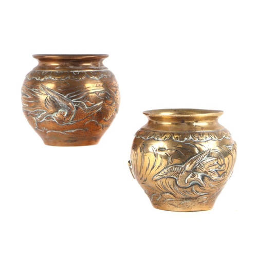 862 - Two Japanese brass vases decorated in relief with phoenix and cranes, 10cms high (2).