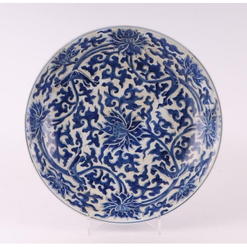 881 - A large Chinese blue and white shallow bowl decorated with flowering foliage, six character mark to ... 