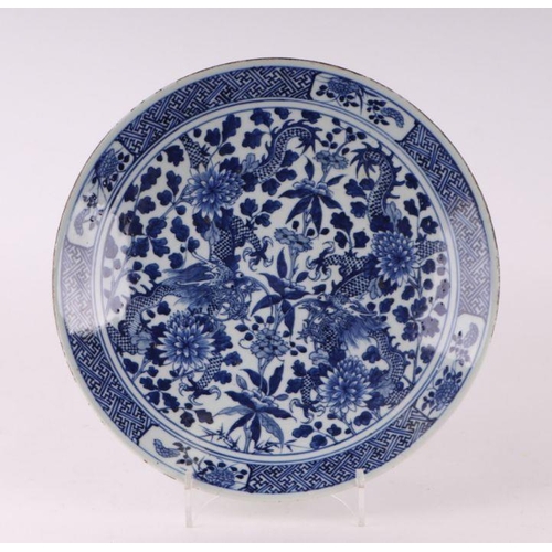 881 - A large Chinese blue and white shallow bowl decorated with flowering foliage, six character mark to ... 