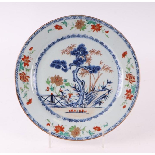 882 - A Chinese famille rose charger decorated with a fir tree and a terrace, 32cm diameter.