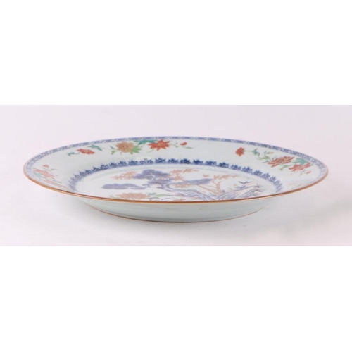 882 - A Chinese famille rose charger decorated with a fir tree and a terrace, 32cm diameter.