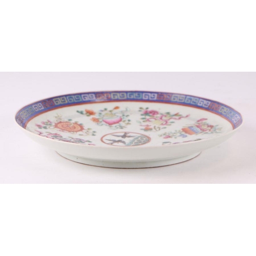 888 - A Chinese famille rose plate decorated with a pair of birds within a border of precious objects, red... 