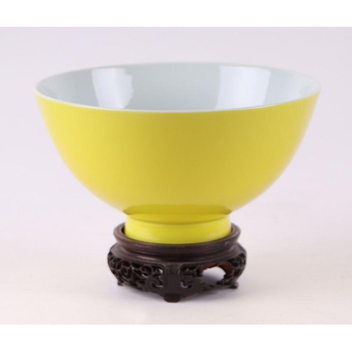 890 - A Chinese Imperial yellow footed bowl with blue seal mark to the underside, on pierced hardwood stan... 