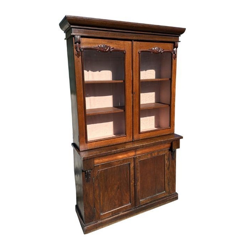 910 - A Victorian bookcase on cupboard, the pair of glazed doors enclosing a shelved interior with cupboar... 