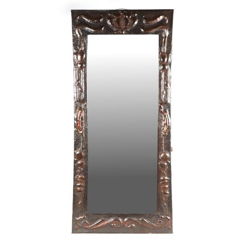 912 - An Arts & Crafts rectangular copper wall mirror in the manner of Liberty, with repousse and enamel d... 