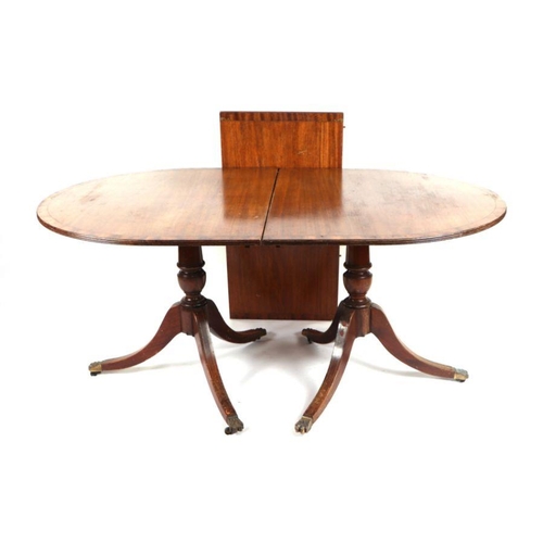 916 - A Regency style twin pedestal mahogany dining table with one extra leaf, 210cm wide extended.