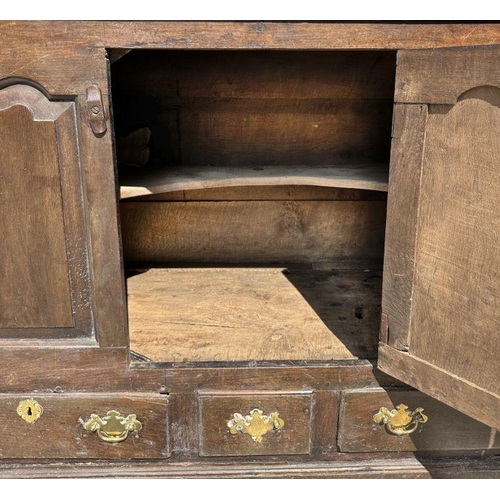 947 - A 19th century oak dresser base with three panelled doors above three drawers, on a shaped apron, 14... 