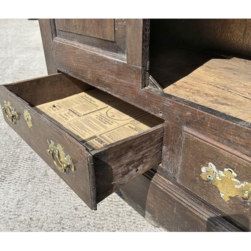 947 - A 19th century oak dresser base with three panelled doors above three drawers, on a shaped apron, 14... 