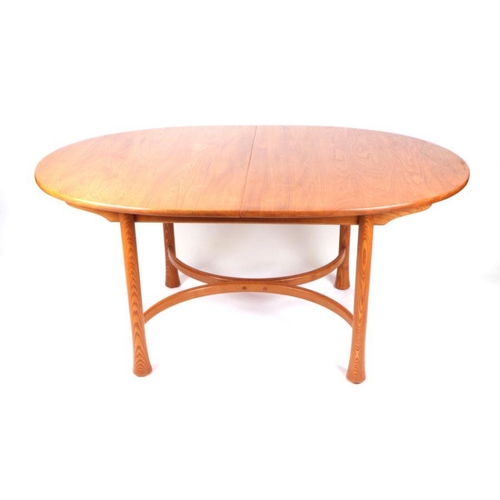 948 - An Ercol elm oval extending dining table on turned legs with  shaped stretcher, 108cm by 162cm not e... 