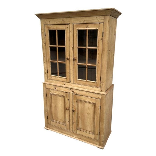 949 - A stripped pine dresser, the superstructure with glazed doors and cupboard beneath, 106cm wide.