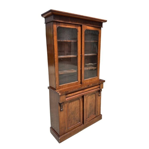 951 - A Victorian mahogany bookcase on cupboard, the pair of glazed doors enclosing a shelved interior, fr... 