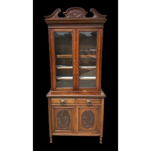 960 - An Edwardian walnut bookcase on cupboard with twin swan necked arched pediment above a pair of glaze... 