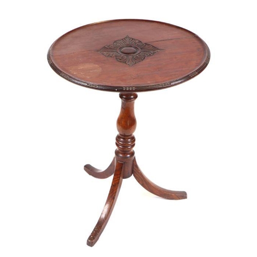 961 - A 19th century mahogany tripod table, the circular dished top with central carved decoration, on a b... 