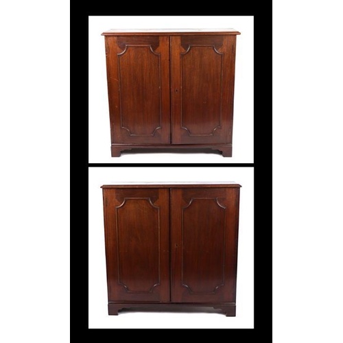 977 - A pair of Victorian mahogany bookcases, each with a pair of panelled doors enclosing shelves, on bra... 