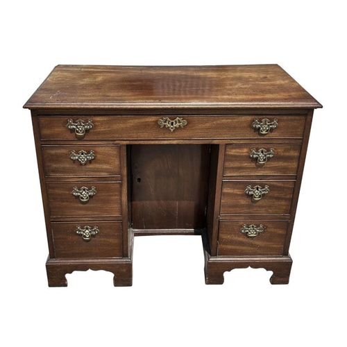 985 - A 19th century mahogany kneehole desk, the central cupboard flanked by an arrangement of seven drawe... 