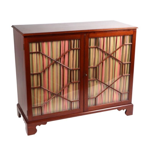 992 - A George III style walnut side cabinet with twin astragal glazed doors enclosing a shelved interior,... 