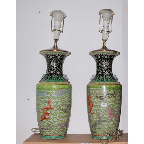 898 - A pair of Chinese famille vert vase table lamps decorated with dragons amongst waves; six character ... 